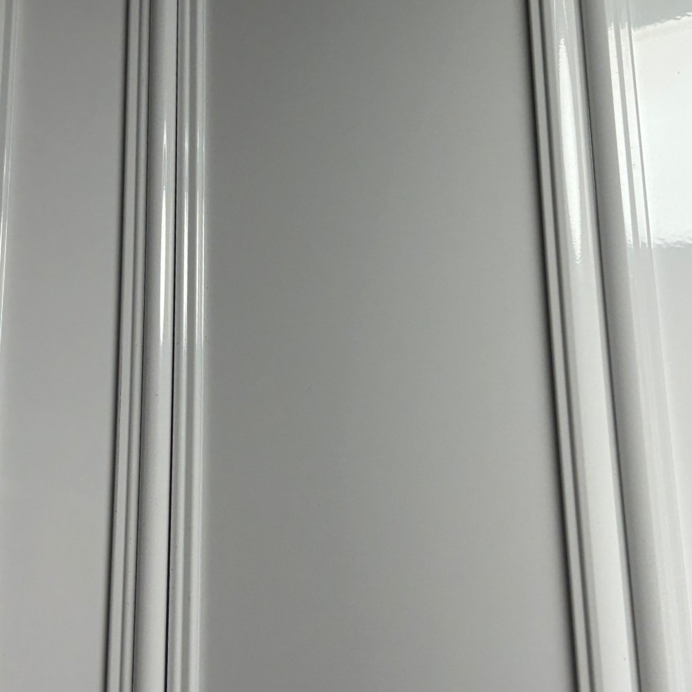 Primer plano de la cortina de duela ciega del Modelo Discreta, mostrando la textura de aluminio blanco brillante y los postes de articulación vertical.