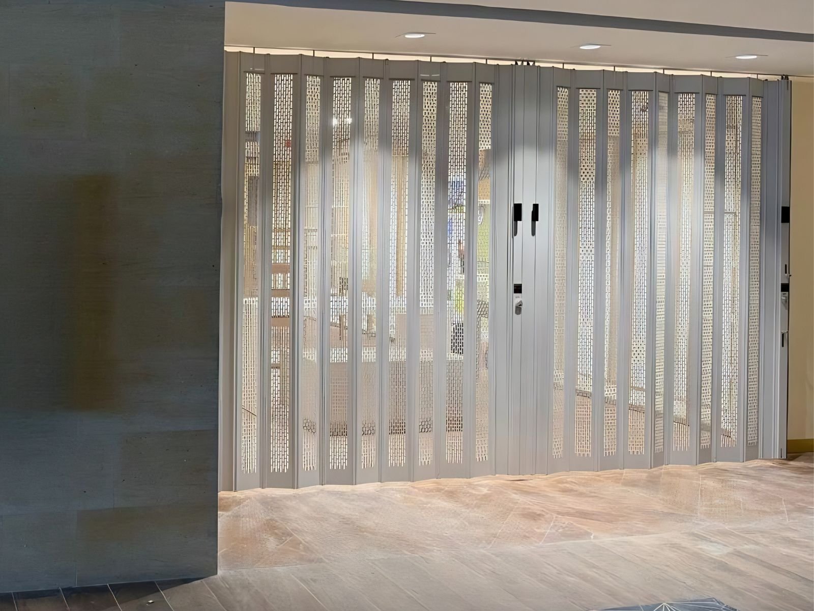 Modelo Aíra: cortina troquelada y cortina de aluminio perforada protegiendo la entrada de un local comercial.