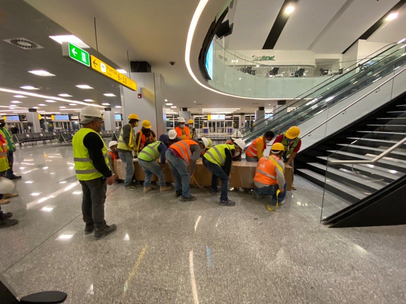 Equipo técnico trabajando en el montaje de cortinas plegadizas en una plaza comercial. Contacta.